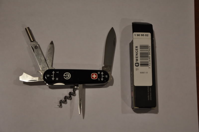 I do not know the name of this SAK. However, it is designed as an accesory for the Swiss SIG 550-series assault rifle, or Sturmgewhr 90 issue assault rifle. Tools: fingernail file, large blade, combo tool (can opener, screwdriver, bottle oopener, wire stripper), corkscrew, awl, fixed screwdriver at end of knife, sight adjustment tool, toothpick and tweezers, no key ring. Black scales with special SIG/Swiss Army acceptance stamp logo;